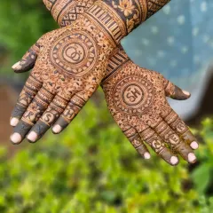 A popular way to personalize your mehendi is with initials. This design features the couple's initials 'S' and 'H' in beautiful circular frames on each palm.