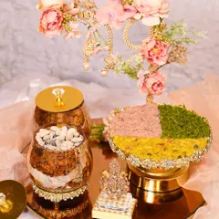 This grand hamper for Ganesh Chaturthi features a floral-decorated platter of fusion mithai, jars of dry fruits, and other festive elements, making it a centerpiece of your celebration.