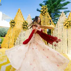A happy bride twirling in her beautiful Haldi outfit, with a backdrop of marigold flowers. This shot is all about movement, color, and joy.