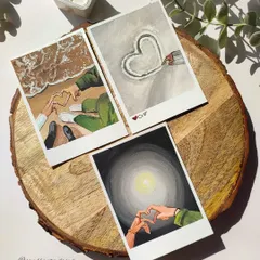 A set of three polaroid paintings celebrating love. These gouache illustrations show different ways of expressing affection, from making hearts with hands on the beach to a simple heart drawn in the snow.