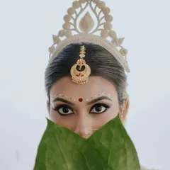 There is a unique poetry to Bengali bridal traditions. For my bride Archita, we focused on the iconic elements: the expressive kohl-lined eyes, the intricate bindi art, and the radiant glow, all framed by the betel leaves during the Shubho Drishti ritual.