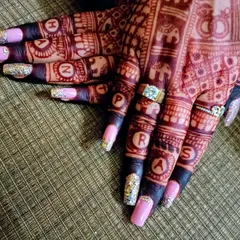 An example of personalized bridal nail art. These extensions feature a glitter accent and the groom's name initialed in the henna design, a special touch I teach for wedding clients.