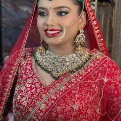 A beautiful smile from a happy bride. Her makeup features a classic red lip and subtly defined eyes, a perfect combination for her green and white Kundan jewelry.