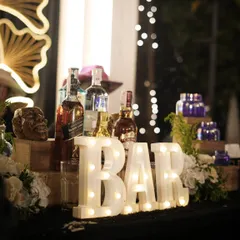 Always setting the bar high. A close-up of our stylish bar setup, complete with marquee lights and a premium selection of spirits.