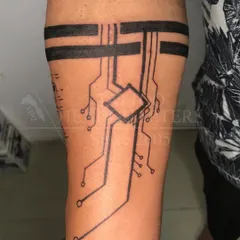 A tech-inspired armband tattoo designed to look like a circuit board, a unique and modern take on the classic band.