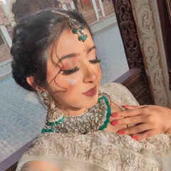 A close-up of a high-glam photoshoot look. This features dramatic winged eyeliner, full lashes, and a bold matte lip, paired with an intricate hairstyle and heavy jewelry for a stunning result.