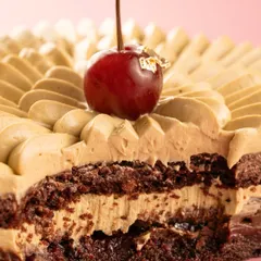 A cross-section of a black forest cake, revealing the layers of cream, chocolate, and cherry. The close-up highlights the rich texture.