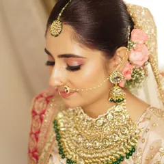 The lovely Aakriti on her wedding day, glowing with subtle elegance. Her look was crafted with soft pink tones on the eyes and cheeks, paired with a flawless base to let her natural radiance shine through.