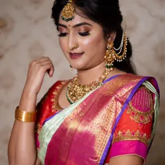 A beautiful profile shot that highlights the glowing skin and detailed eye makeup. The subtle winged liner and shimmering shadow create a look that is both traditional and glamorous.