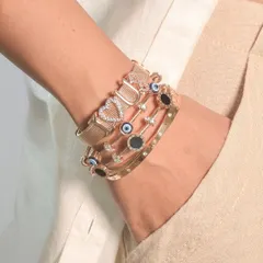 A chic and modern wrist stack. This look layers a personalized 'LOVE' mesh bracelet with delicate evil eye bangles for a balanced and stylish vibe.