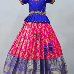 A vibrant royal blue blouse paired with a pink Banarasi skirt. The blouse features a beautifully embroidered neckline and puff sleeves, adding a touch of grandeur.