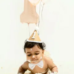 Fully embracing the mess. This little one is crawling through the cake and frosting, a perfect shot that captures the hilarious and adorable chaos of a cake smash session.