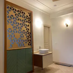 A closer look at the custom-designed partition and vanity unit. The combination of wood, green, and cream laminates creates a distinctive and stylish look.