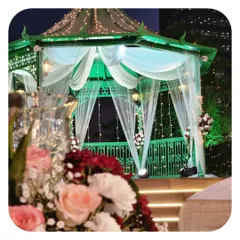 An elegant gazebo decorated for an evening event. We used sheer white drapes, fairy lights, and floral accents to transform this structure into a romantic and enchanting focal point.