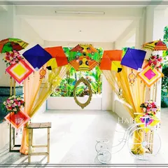 A playful and vibrant entrance designed for a pre-wedding celebration. This themed decor uses colorful kites, decorative umbrellas, and a vintage-style bicycle to create a fun, festive atmosphere that welcomes guests with a unique touch.