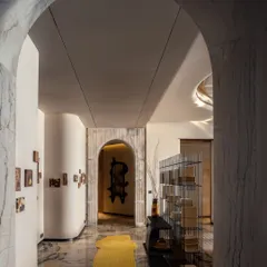 This sculpted curve in the Palais Royale apartment guides movement with intention, softening the geometry of the home’s asymmetric layout. Subtle brass accents, exquisite marble, and fluted detailing elevate this in-between space into a spatial highlight.