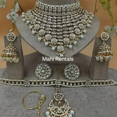 A complete white Kundan bridal set including a heavy choker, jhumkas, hathphool, nath, and maang tikka.