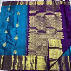 An authentic Kanchipuram handwoven silk saree, certified with the Silk Mark for purity. This piece showcases traditional elephant motifs woven with pure 2g zari against a beautiful blue silk, paired with a rich purple pallu.