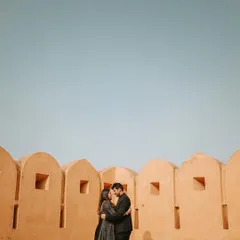 Using negative space to create a powerful image, this couple is framed against the ramparts of an ancient fort under a vast blue sky, creating a sense of timelessness.