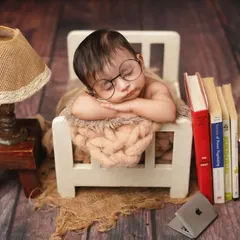 A different angle of the 'tiny scholar' theme, showing the baby sleeping soundly in his miniature bed, surrounded by books.