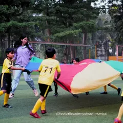 A coach joins in on the parachute game, making training fun and building a strong connection with the players.