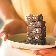 A stack of our Power-up Cubes, held in hand to show their perfect, snackable size. These vegan and sugar-free bites are designed to fuel your day without compromising on taste.