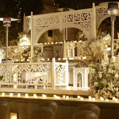 The custom-built white balconies, adorned with florals and surrounded by hundreds of candles. This design transformed the venue's architecture to create an intimate and traditional setting for the Sufi night.