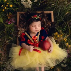 My very own Snow White. This newborn is dressed as the classic princess, sleeping peacefully in a digital forest setting with a red apple.