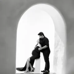 Sometimes, the most powerful stories are told in black and white. This intimate couple portrait, framed by a simple archway, focuses purely on the connection and anticipation between two people about to become parents.