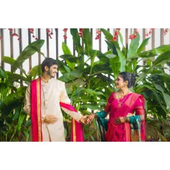 A candid moment of connection between the couple in their traditional outfits. Holding hands and sharing a look, this photo tells a story of partnership and shared heritage.