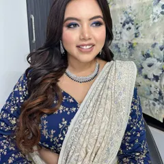 The intensity of the blue eyeshadow is balanced with a neutral lip and glowing skin. This ensures the look is dramatic but still feels polished and elegant.