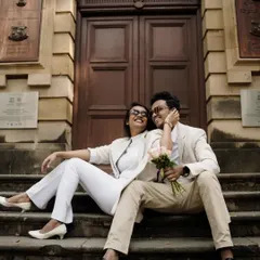 Sharing a laugh on the steps of a historic building. It’s a beautiful blend of candid happiness and sophisticated style.
