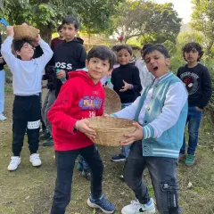 A playful moment between two boys with their harvesting baskets during a fun day out on the farm.