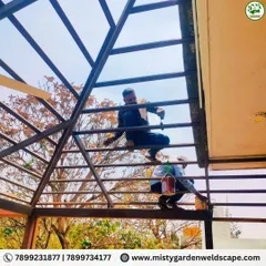 Workers on the roof, assembling the metal framework. I ensure all my structures are properly anchored and built to withstand the elements.