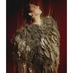 Another look from the Elle Digital cover shoot, this time with a focus on texture and light play. The motion blur and warm, directional light highlight the intricate details of the golden, feather-like garment.