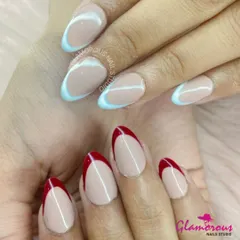A bold and graphic design with a split-hand look. One hand features a striking red V-shaped French tip, while the other has a cool light blue, both on a clean nude base.