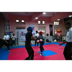 Two athletes sparring during the Mumbai City District Kickboxing Championship. With a referee overseeing the match, our fighters demonstrate the discipline and control that is central to the sport of kickboxing.