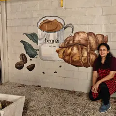 A mural designed for the outdoor area of 'bean&' cafe. This piece features their signature offerings, coffee and croissants, painted in a realistic style to create an appetizing and brand-centric visual.
