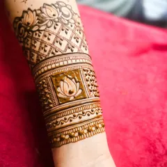 A beautiful engagement henna design featuring lotus motifs and delicate latticework on the forearm. This is a perfect example of elegant and modern bridal art.