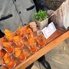 Our crispy chicken bites are a party favorite. Here they are served in individual shot glasses with a tangy dipping sauce at the bottom, making them easy for guests to enjoy while mingling.