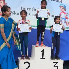 Young skaters from our academy on the winners' podium at the Interschool Skating Competition, proudly holding their certificates and medals.