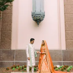 A moment of connection before the ceremony. Nisha in a traditional orange Sabyasachi Banarasi lehenga and Vishal in a contrasting ivory and mint sherwani by Jayanti Reddy. A beautiful blend of cultures and colors.
