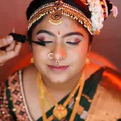 This image shows a traditional bridal bun, elegantly decorated with jasmine and other flowers. This hairstyle is perfect for securing a heavy dupatta or veil and is a timeless choice for Muhurtham ceremonies.
