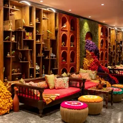 We create inviting lounge areas for guests to relax and connect. This setup features traditional Indian diwans, colourful poufs, and intricate wooden shelving, creating a warm and culturally rich ambiance.