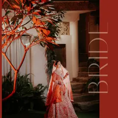 A dramatic and artistic portrait of the bride, illuminated by a single light source, highlighting the rich color of her lehenga and her serene expression.