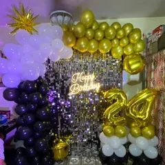 This shimmer backdrop combines a silver wall with black and gold balloons. We also added marquee numbers and a starburst foil balloon to complete the look for this 24th birthday.