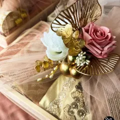 This shot showcases how I layer different textures, from the soft pastel netting to the embroidered fabric of the gift and the metallic floral accents, to create a visually stunning presentation.