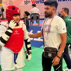 A quiet moment of strategy and encouragement with my student before he steps onto the mat for his bout at the international competition.