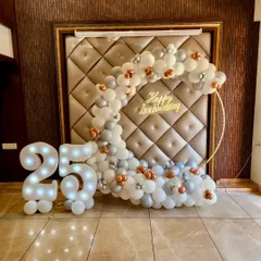 For this 25th wedding anniversary, we designed an elegant crescent balloon arch in silver, white, and rose gold. The light-up '25' and 'Happy Anniversary' neon sign make for a perfect photo opportunity to celebrate the silver jubilee.