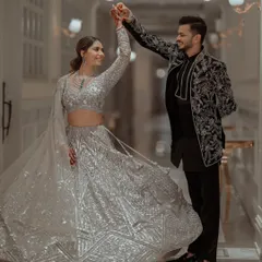 A beautiful shot of the couple twirling in a grand corridor, the bride's silver lehenga catching the light perfectly.